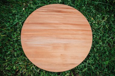 Yeşil çim arka planda yuvarlak ahşap tahta