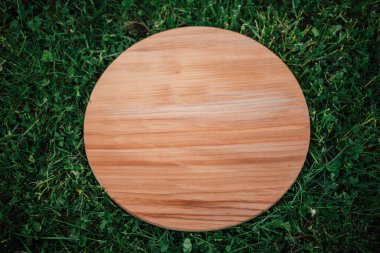 Yeşil çim arka planda yuvarlak ahşap tahta