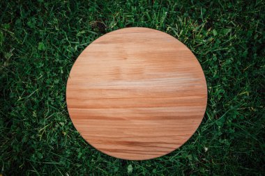 Yeşil çim arka planda yuvarlak ahşap tahta