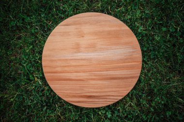 Yeşil çim arka planda yuvarlak ahşap tahta