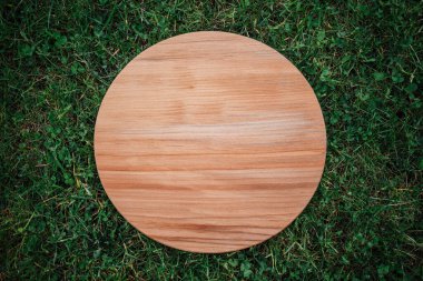 Yeşil çim arka planda yuvarlak ahşap tahta