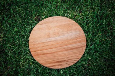 Yeşil çim arka planda yuvarlak ahşap tahta