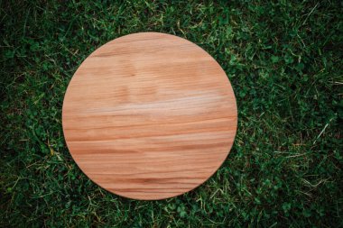 Yeşil çim arka planda yuvarlak ahşap tahta