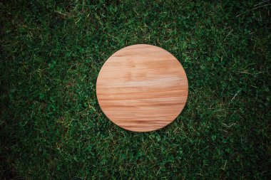 Yeşil çim arka planda yuvarlak ahşap tahta