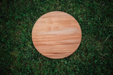 Yeşil çim arka planda yuvarlak ahşap tahta