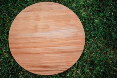 Yeşil çim arka planda yuvarlak ahşap tahta