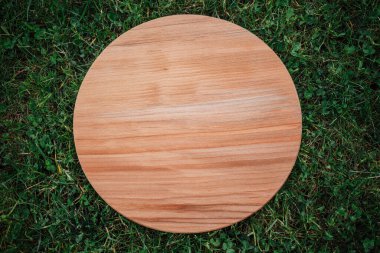 Yeşil çim arka planda yuvarlak ahşap tahta