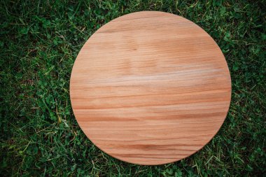 Yeşil çim arka planda yuvarlak ahşap tahta
