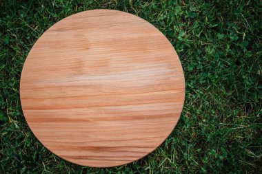 Yeşil çim arka planda yuvarlak ahşap tahta