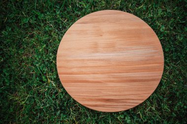 Yeşil çim arka planda yuvarlak ahşap tahta
