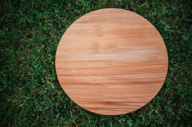 Yeşil çim arka planda yuvarlak ahşap tahta