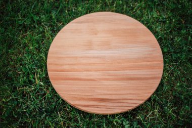 Yeşil çim arka planda yuvarlak ahşap tahta
