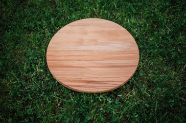 Yeşil çim arka planda yuvarlak ahşap tahta
