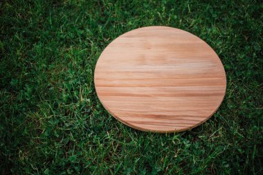 Yeşil çim arka planda yuvarlak ahşap tahta