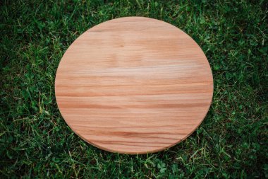 Yeşil çim arka planda yuvarlak ahşap tahta