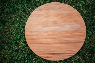 Yeşil çim arka planda yuvarlak ahşap tahta