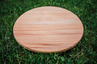 Yeşil çim arka planda yuvarlak ahşap tahta