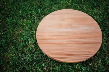 Yeşil çim arka planda yuvarlak ahşap tahta