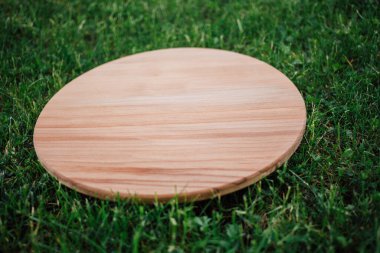 Yeşil çim arka planda yuvarlak ahşap tahta