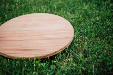 Yeşil çim arka planda yuvarlak ahşap tahta