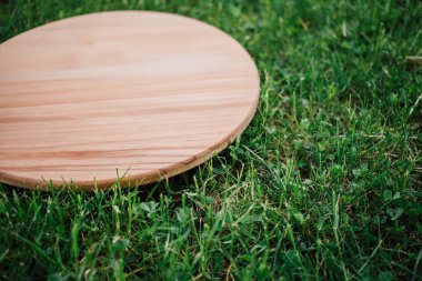 Yeşil çim arka planda yuvarlak ahşap tahta