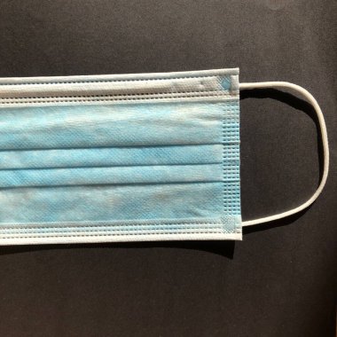 Gri arkaplanda tek kullanımlık yüz maskesi