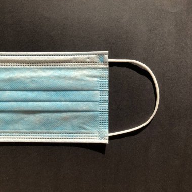 Gri arkaplanda tek kullanımlık yüz maskesi