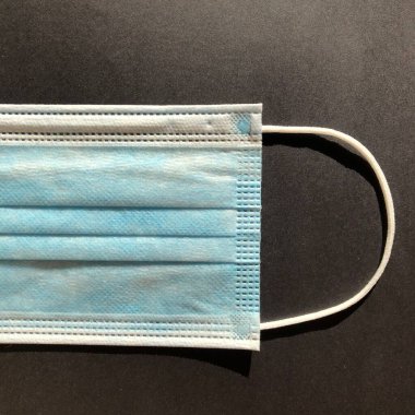 Gri arkaplanda tek kullanımlık yüz maskesi