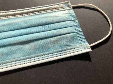 Gri arkaplanda tek kullanımlık yüz maskesi