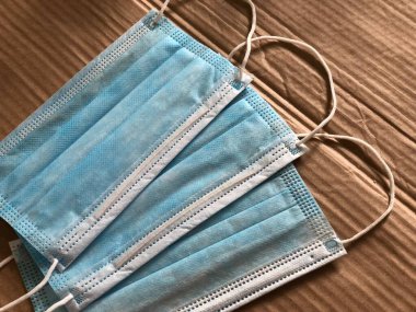 Ahşap arka planda tek kullanımlık yüz maskeleri