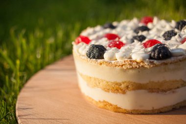 Tahta üzerinde tatlı pasta Çimen arka planda duruyor