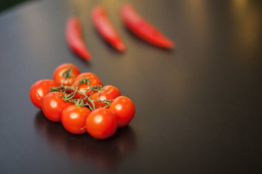Siyah arka planda kırmızı biberli vişneli domateslere yakın çekim
