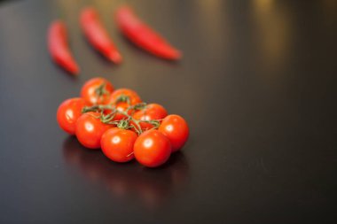 Siyah arka planda kırmızı biberli vişneli domateslere yakın çekim