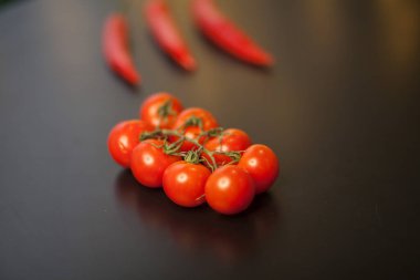 Siyah arka planda kırmızı biberli vişneli domateslere yakın çekim