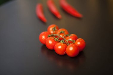 Siyah arka planda kırmızı biberli vişneli domateslere yakın çekim