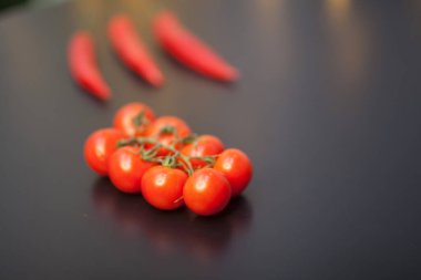 Siyah arka planda kırmızı biberli vişneli domateslere yakın çekim