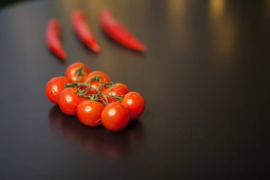 Siyah arka planda kırmızı biberli vişneli domateslere yakın çekim