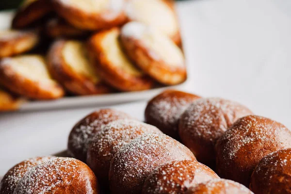 Beyaz masa arkaplanındaki bir tabakta süzme peynirli çörek.