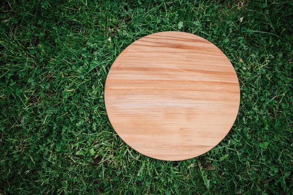 Runde Holzplatte Auf Grünem Gras Hintergrund — Stockfoto