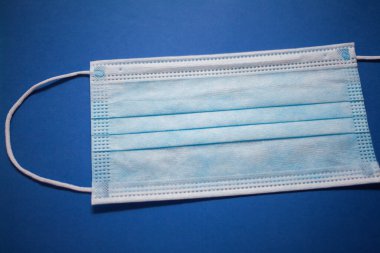 mavi arka plan üzerinde tek kullanımlık yüz maskesi