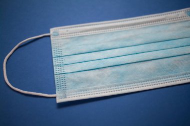 mavi arka plan üzerinde tek kullanımlık yüz maskesi