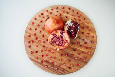 Yuvarlak tahta üzerinde nar meyvesi, yakın çekim. 