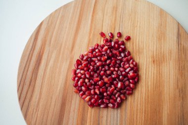 Yuvarlak tahta üzerinde nar tohumları, yakın çekim. 