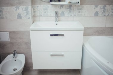 Modern bathroom wash basin with chrome faucet and gray tiling