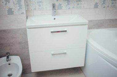 Modern bathroom wash basin with chrome faucet and gray tiling