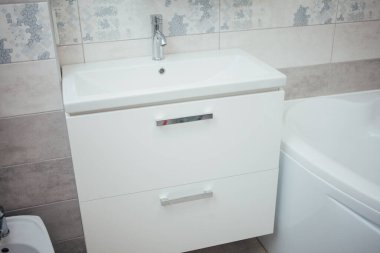 Modern bathroom wash basin with chrome faucet and gray tiling