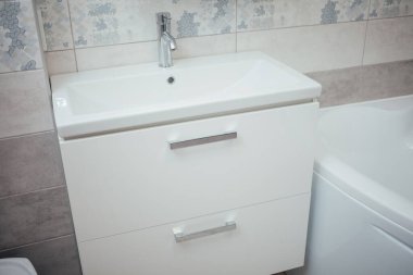 Modern bathroom wash basin with chrome faucet and gray tiling