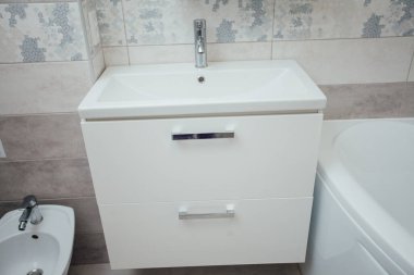Modern bathroom wash basin with chrome faucet and gray tiling