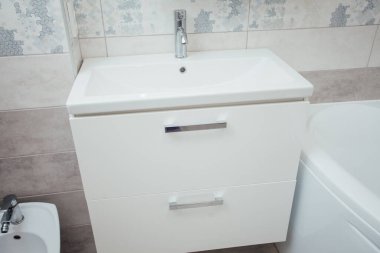 Modern bathroom wash basin with chrome faucet and gray tiling