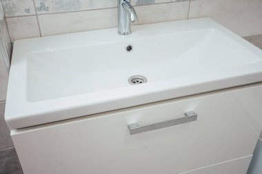 Modern banyo lavabosu krom musluk ve gri fayansla